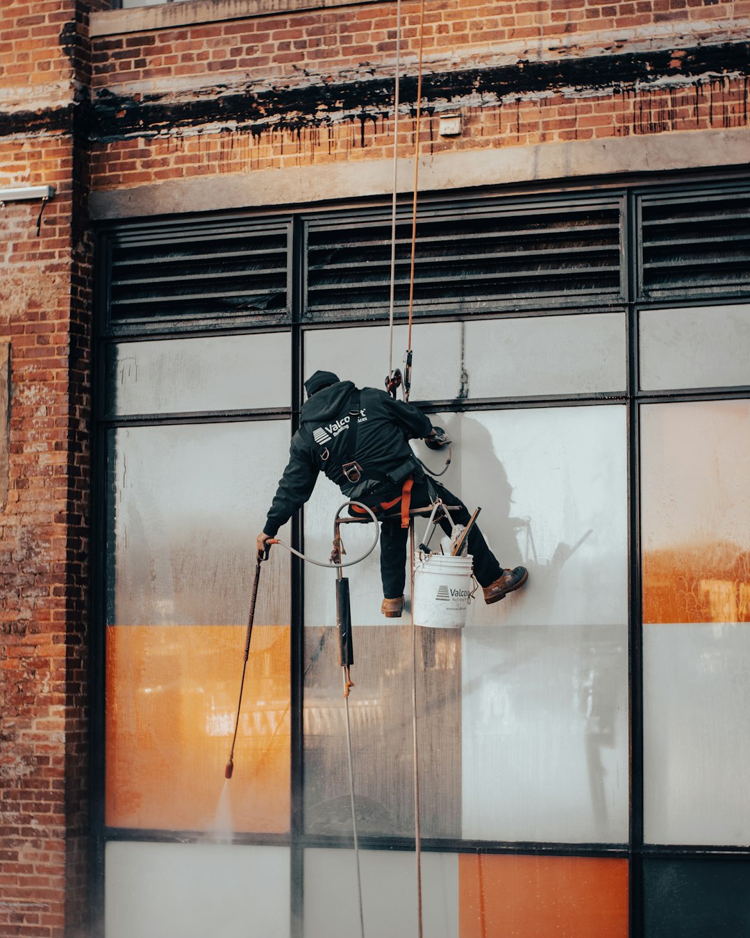 creative-03 a-man-hanging-from-a-rope-on-the-side-of-a-building-kvuojdphbc0